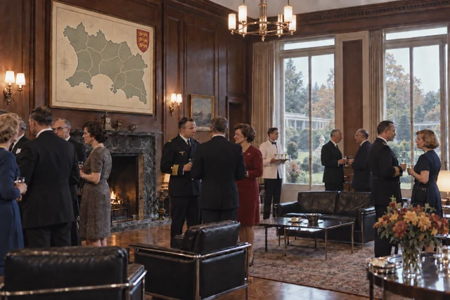 Fictional 1964 Government House reception in a wood-panelled room, with an accurate twelve-parish Jersey map and mixed civilian, naval and Reich officials.